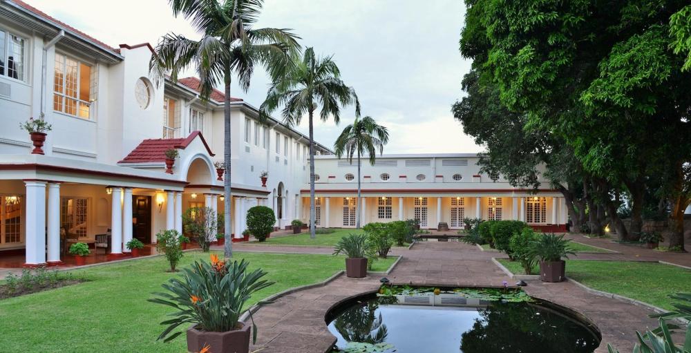 A landscaped garden at The Victoria Falls Hotel is adorned with diverse flora, echoing the charm of the Victoria Falls Hotel.